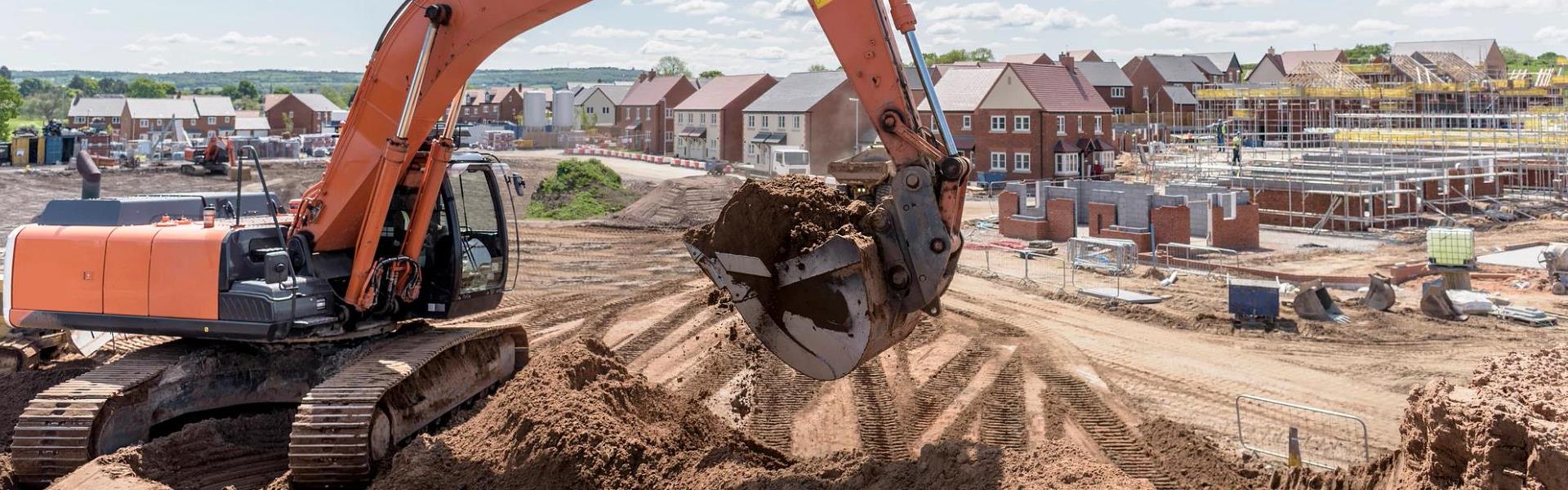 Excavator moving earth on housing building site