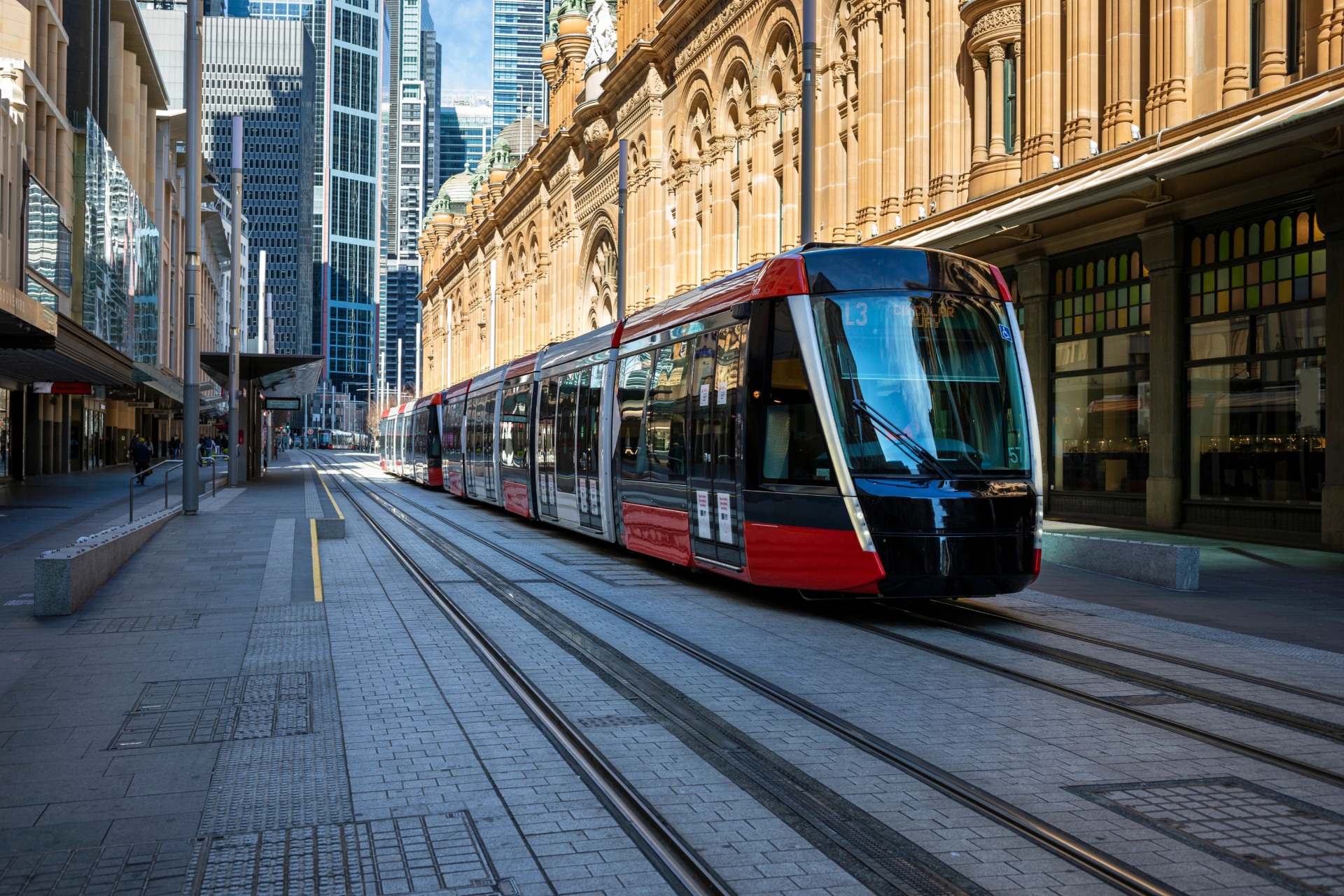 A red and black train traveling on the tracks.