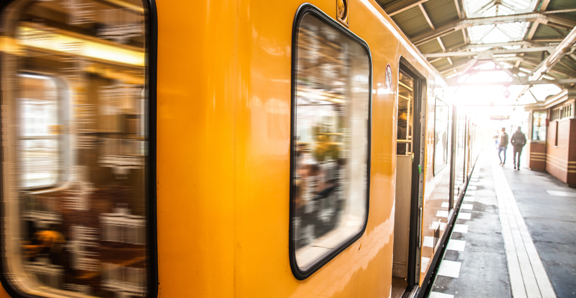 A parked train at a train station, ready for boarding, with platforms bustling with travelers.
