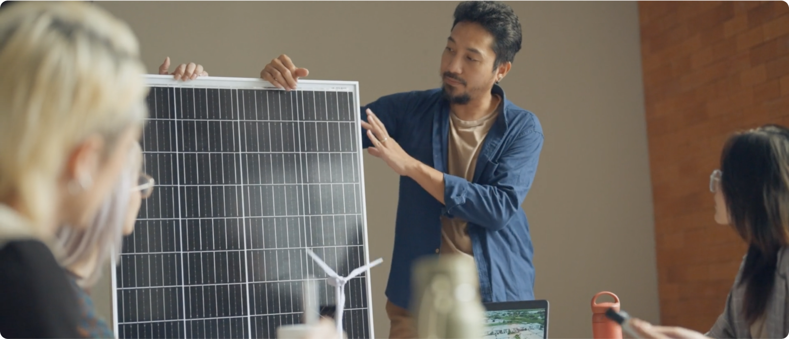 A man and woman inspect a solar panel together, highlighting their interest in sustainable energy technology outdoors.