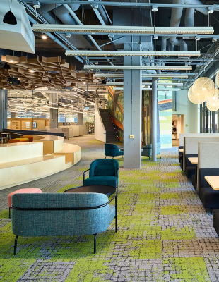An office space featuring a vibrant carpet and colorful chairs, creating a lively and inviting atmosphere for work.