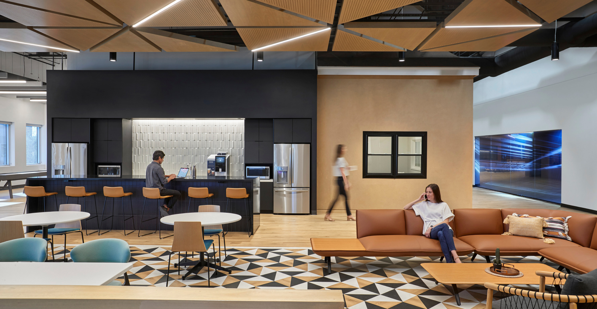 An expansive modern office space featuring an open design, characterized by sleek furnishings and a bright atmosphere.