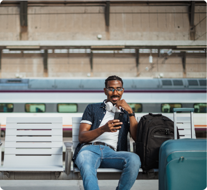 Man sitting on bench looking at phone