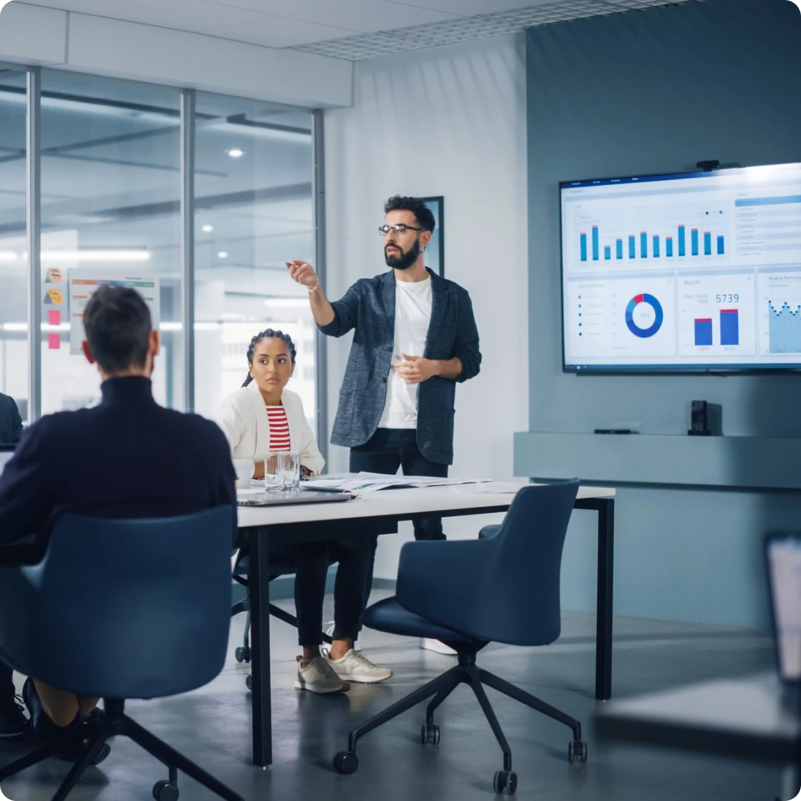 A man presenting to a group of people in a conference room.