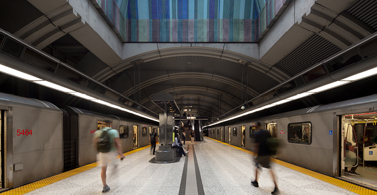 A train approaches the station, with commuters strolling alongside, capturing the essence of daily transit.