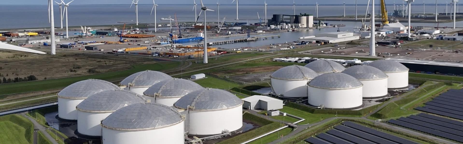 A renewable energy site with wind turbines and solar panels, harnessing wind and sunlight for power generation.