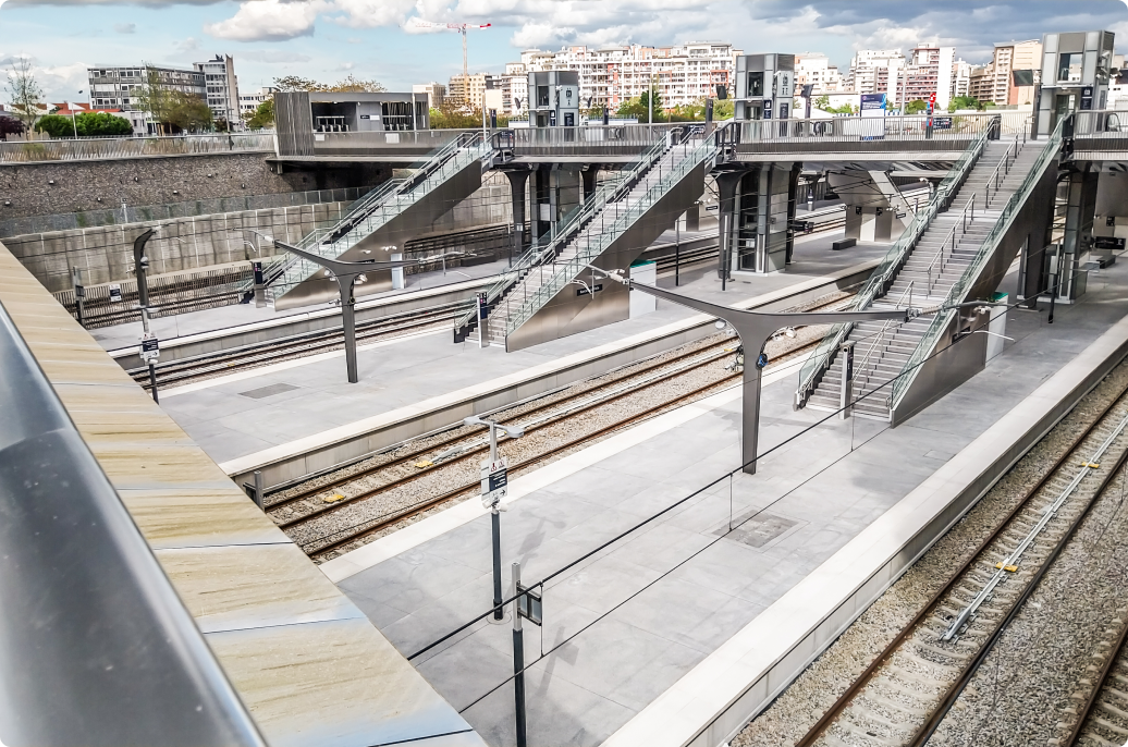 A train station featuring a metal platform and stairs, showcasing a modern design and functional architecture.