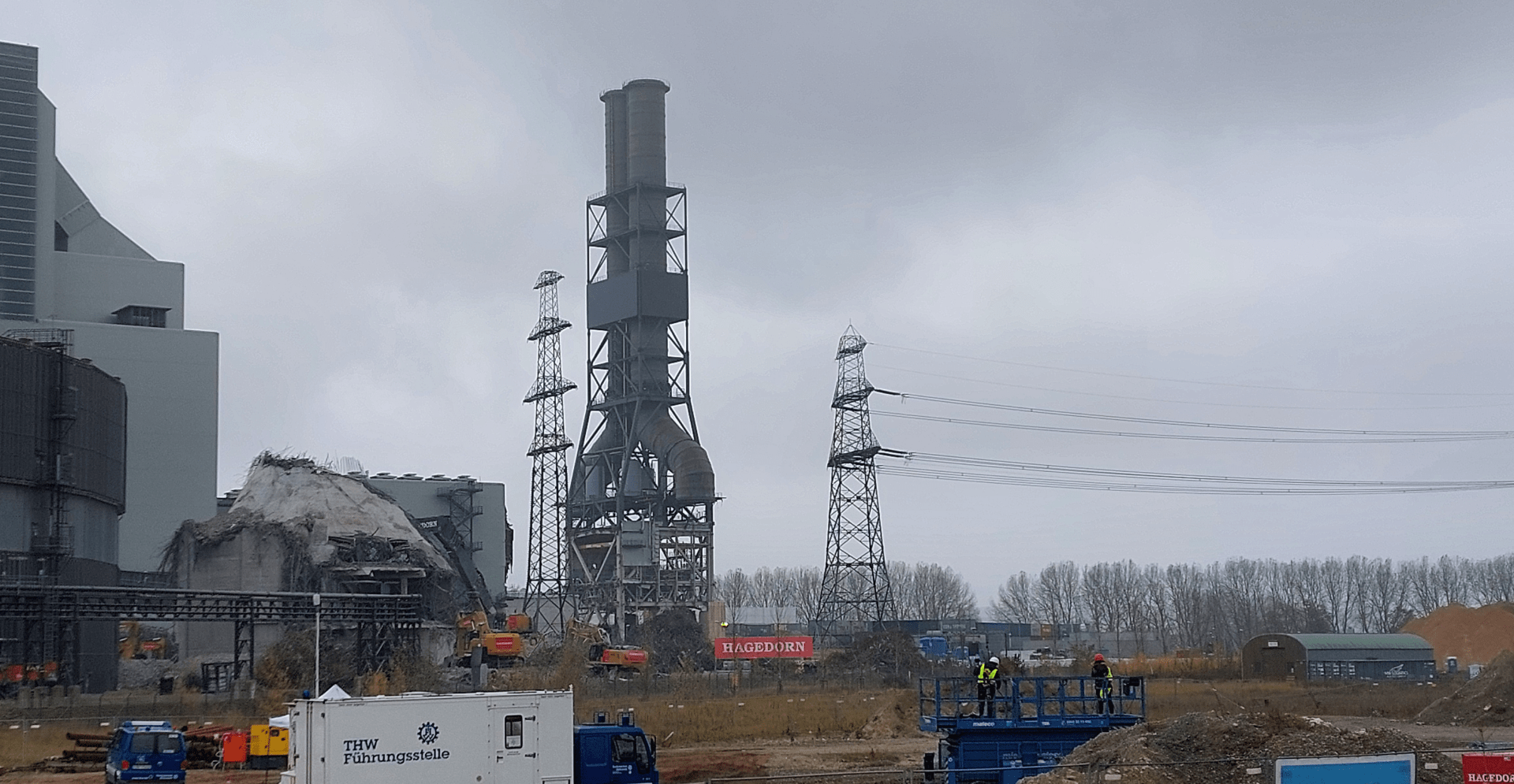 A large factory with a crane in the background, showcasing industrial architecture and machinery in operation.