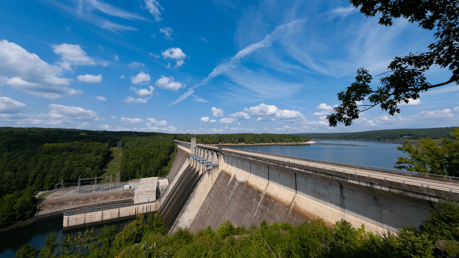 A large dam stands over a vast body of water, showcasing its impressive structure and surrounding landscape.