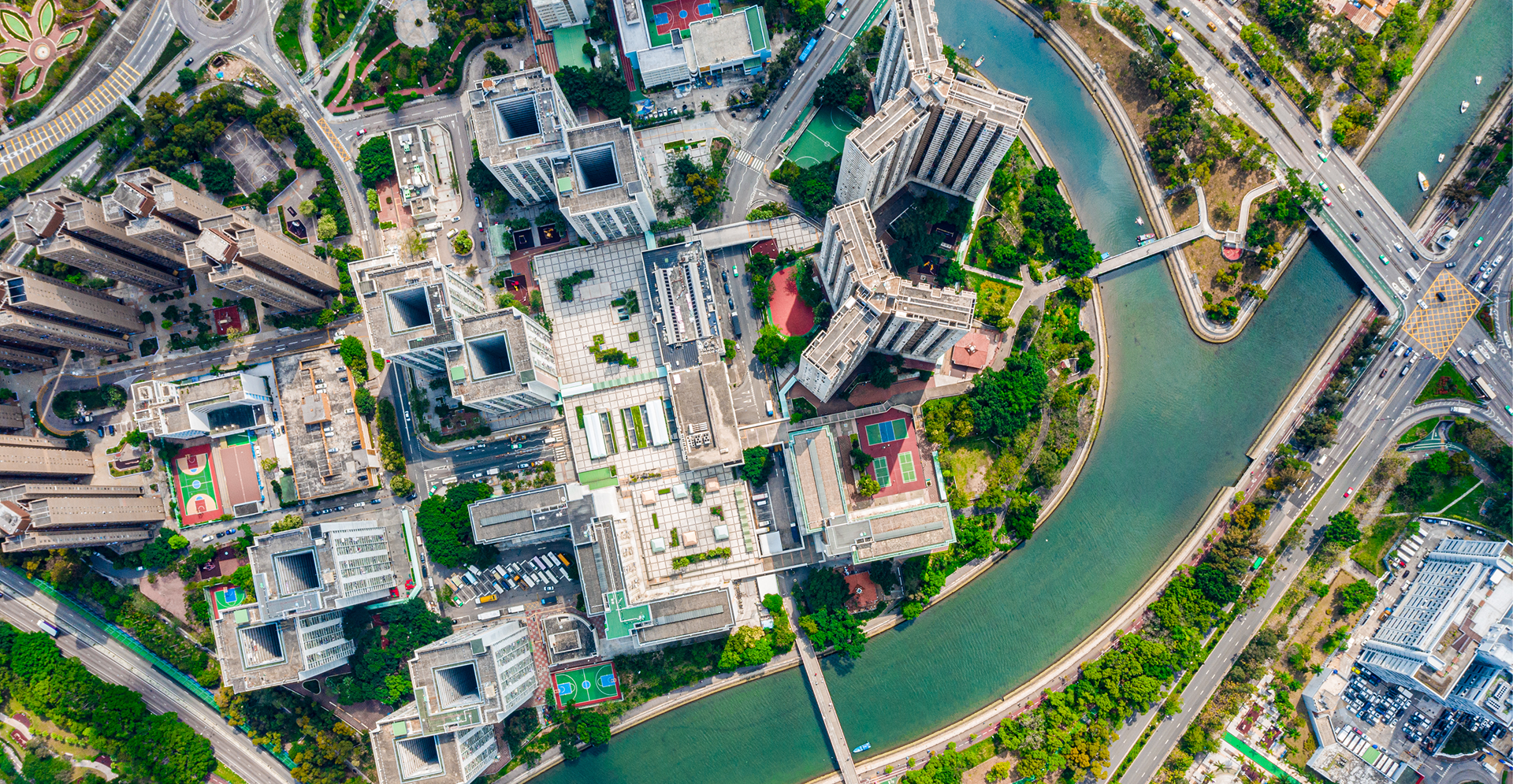 Aerial perspective of a city with a river meandering through its buildings and streets.