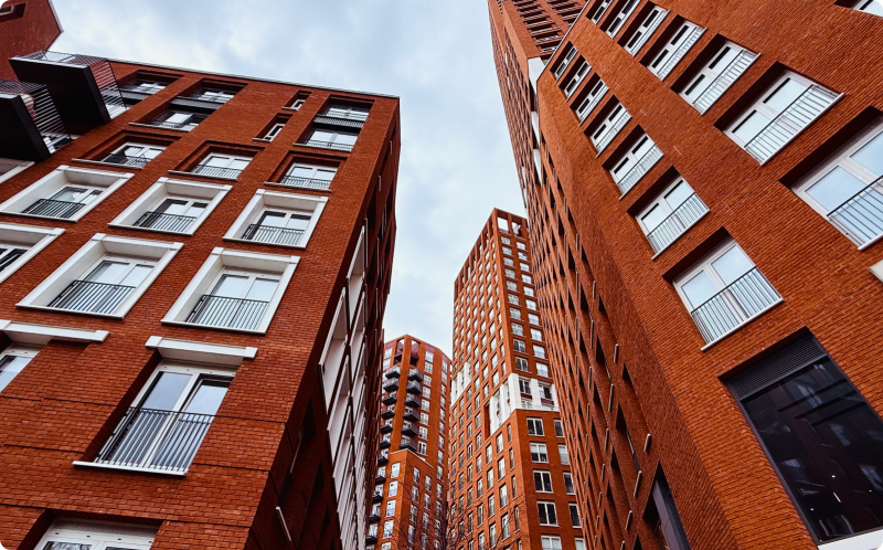 Red brick buildings line a city street, showcasing urban architecture against a clear blue sky.