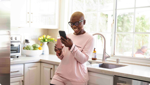 A woman in a pink shirt engrossed in her cell phone, focusing on the screen with intense concentration.