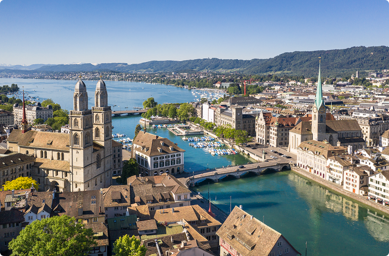 A scenic view of a city featuring a river and a bridge, showcasing urban architecture and natural elements.