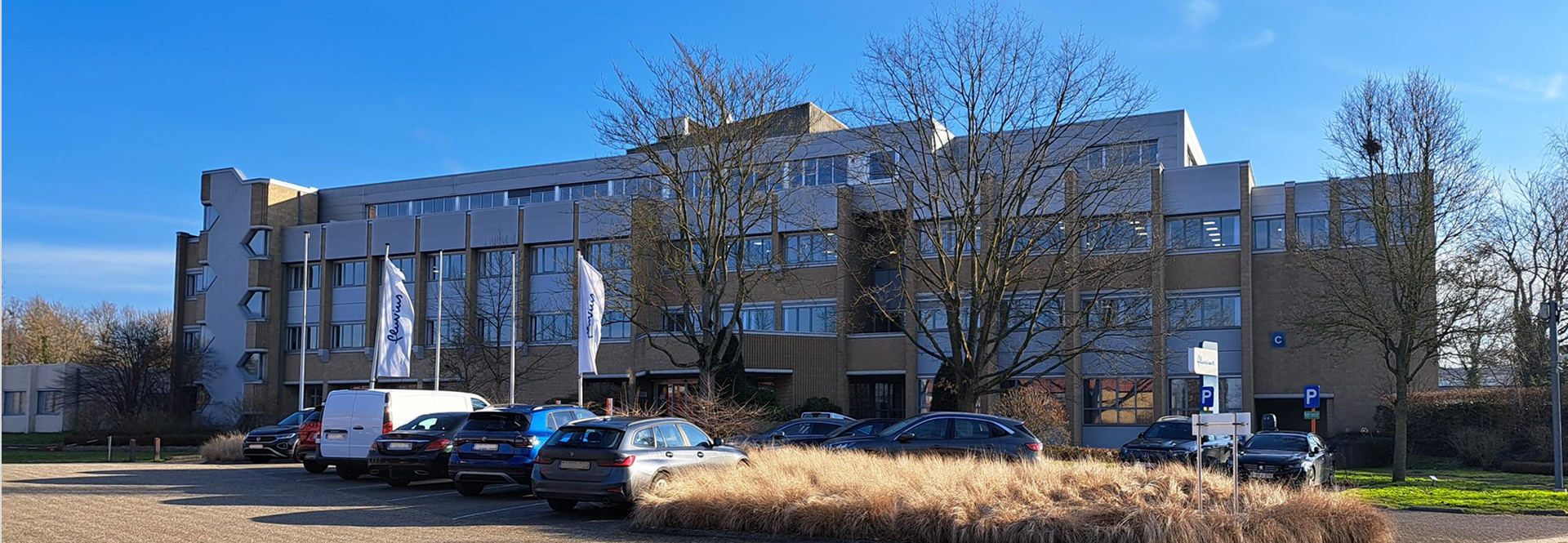 A large building with several cars parked in front, showcasing a busy and accessible environment.