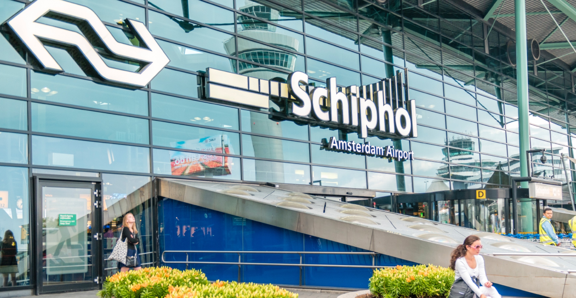 Mensen die entree van vliegveld Schiphol binnengaan