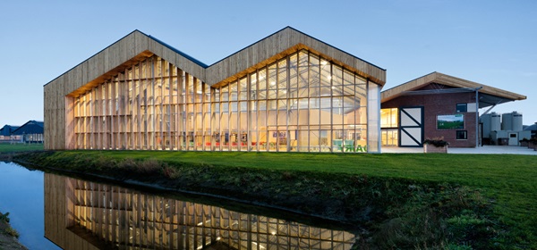 Dairy Campus van proefboerderij tot kenniscentrum Houtengevels bij zonsondergang van buitenaf bekeken