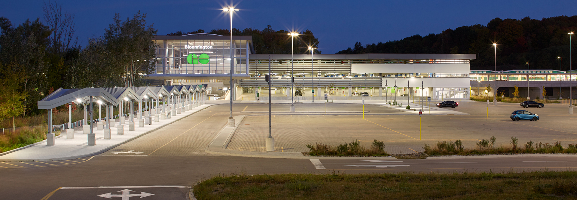A spacious parking lot with numerous vehicles, featuring a large building in the background.