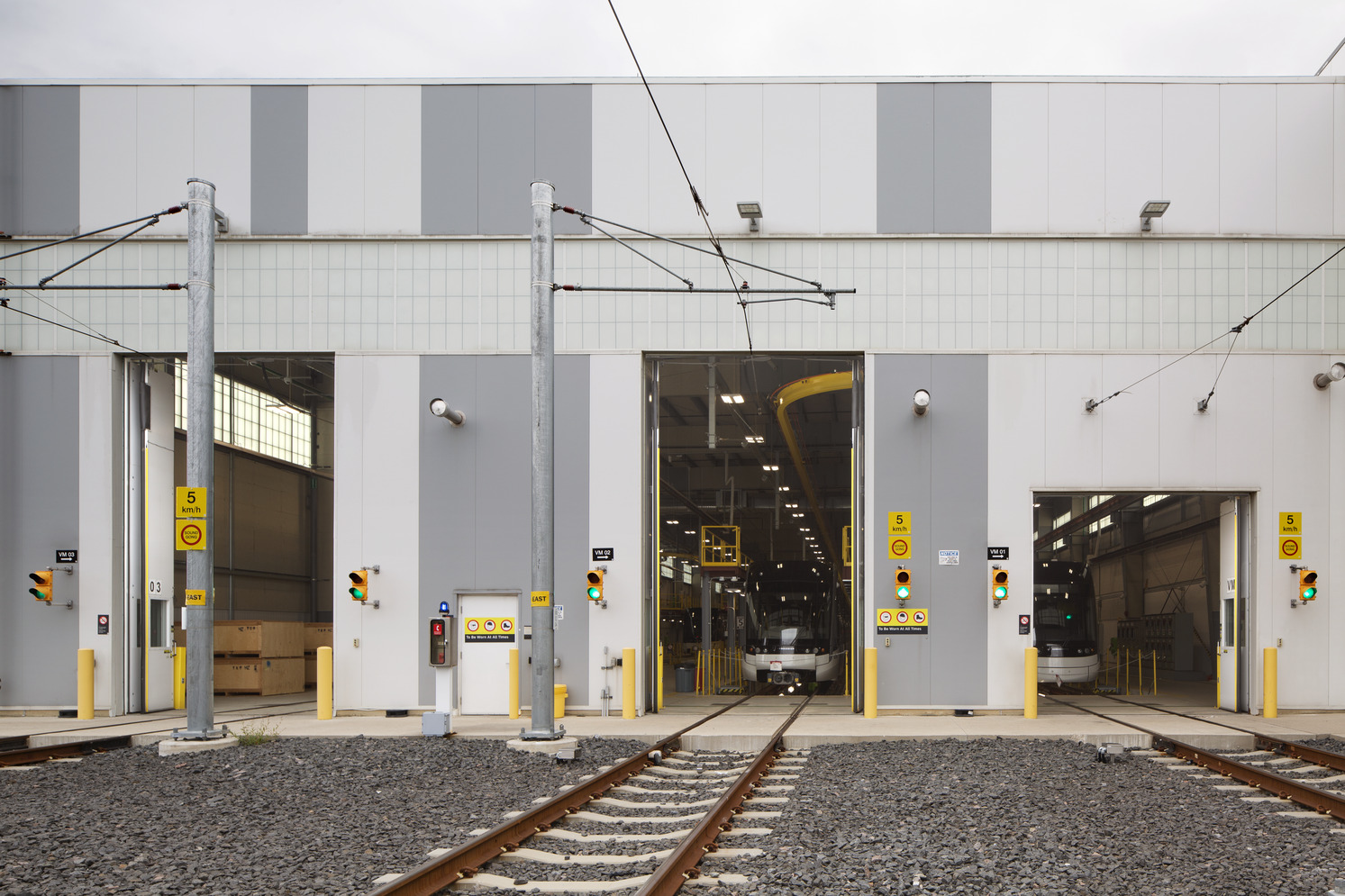 A train station featuring a train on the tracks, with platforms and signage visible in the background.