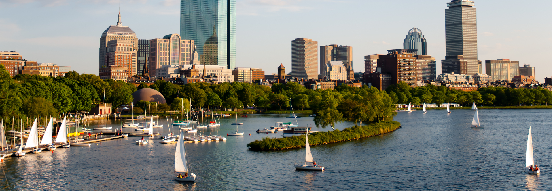 A serene body of water reflecting the sky, surrounded by lush greenery and distant hills.
